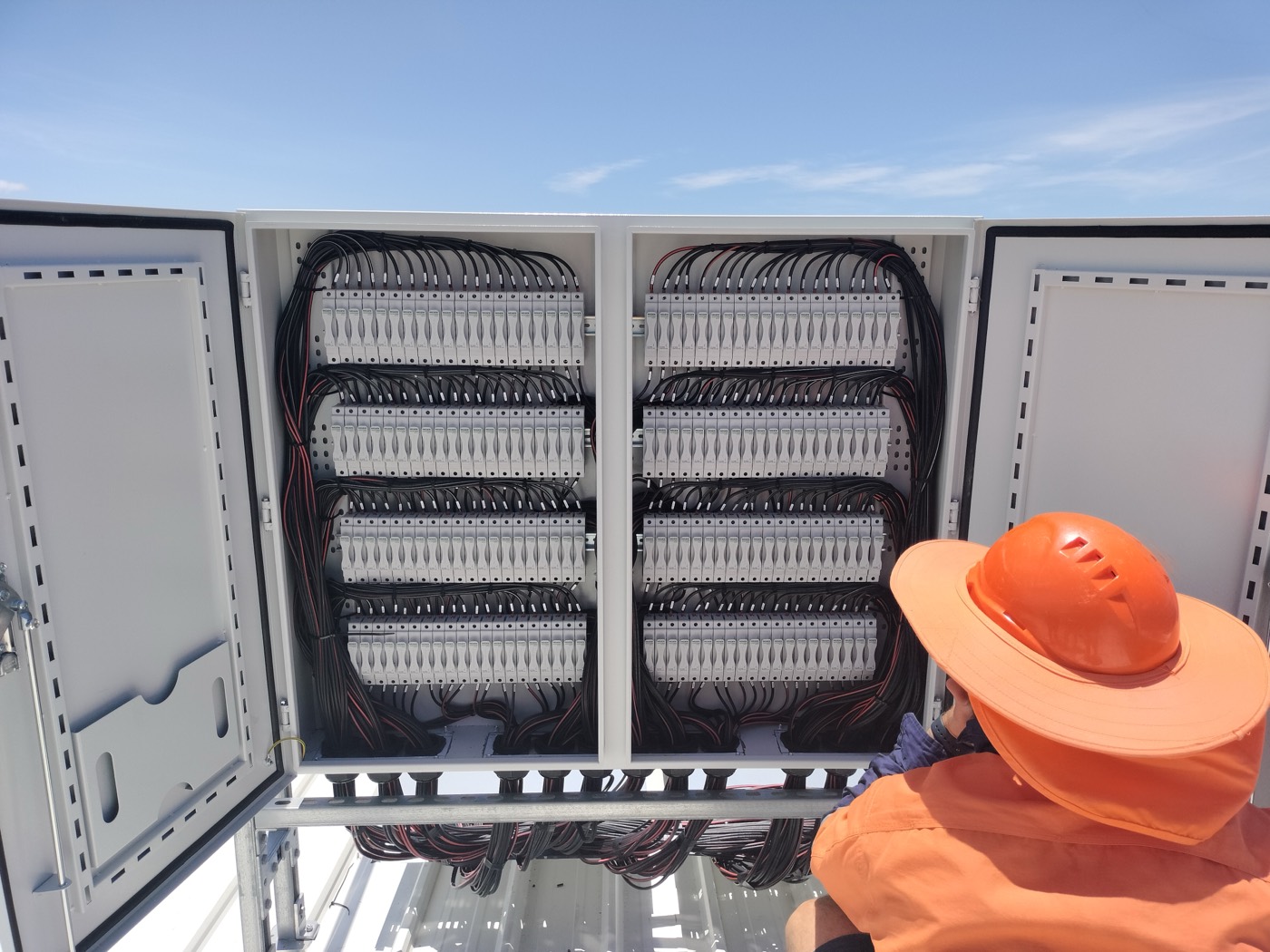 Electrician working on a solar DC combiner board
